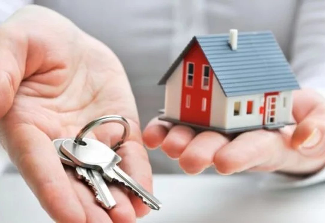 A new homeowner holding up the keys to their house