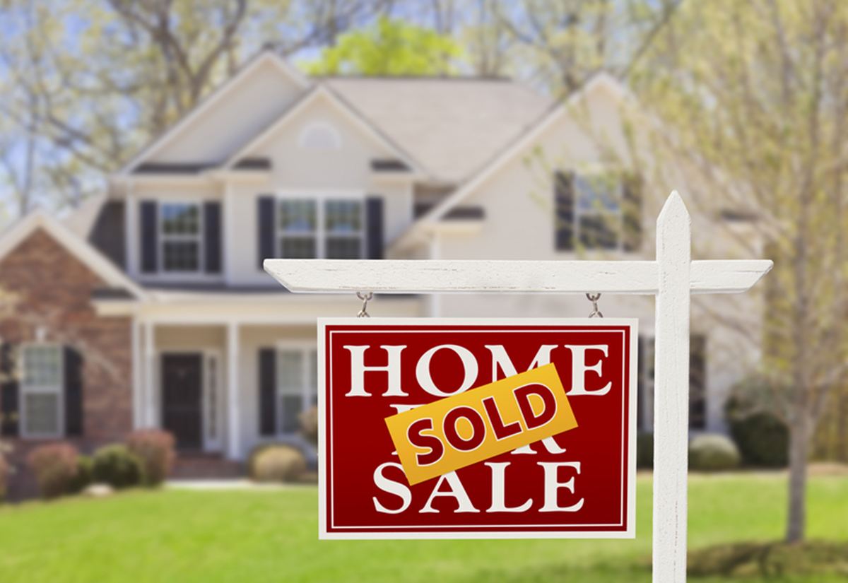 A Home For Sale sign in a front yard